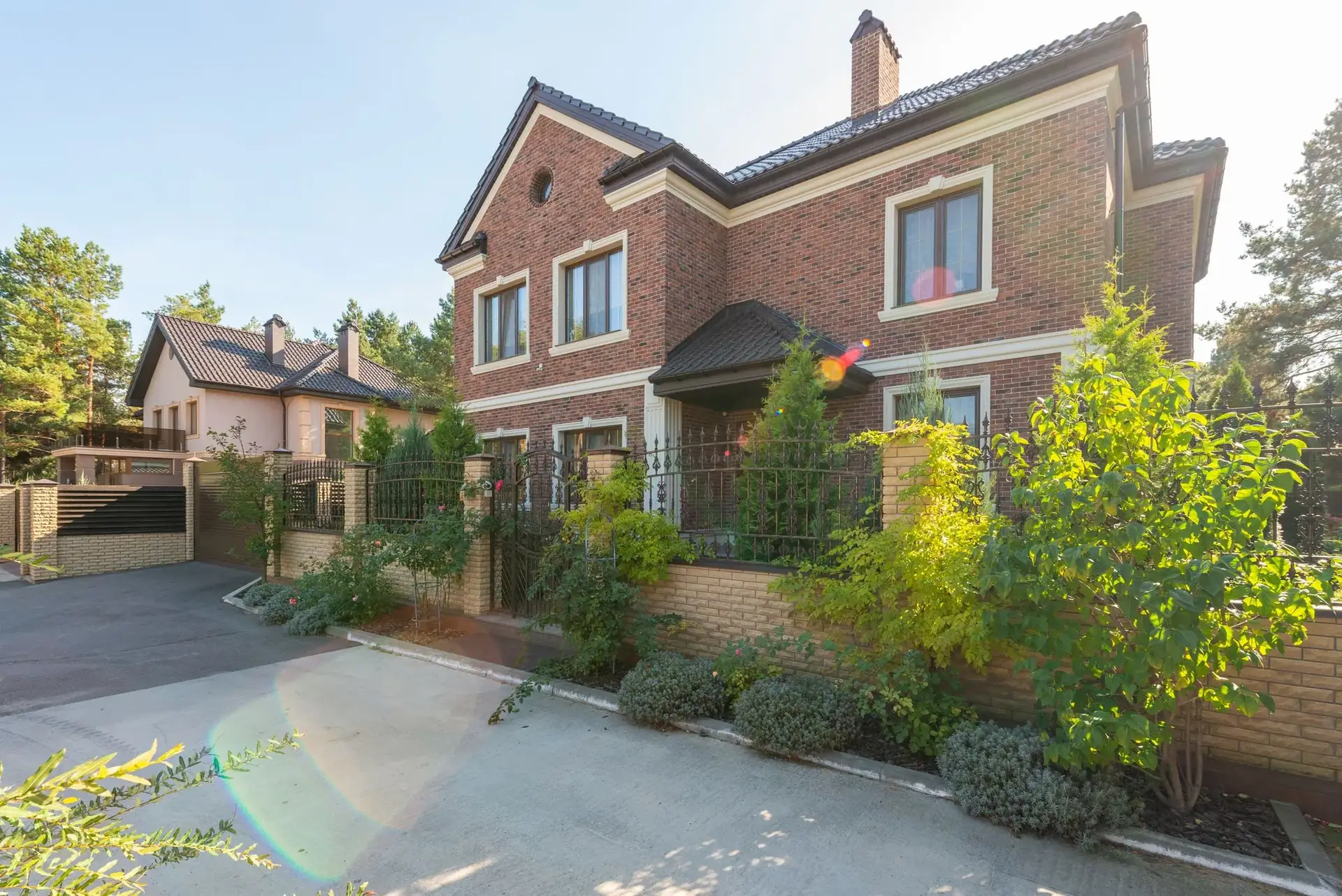 A large brick family home with a landscaped front yard
