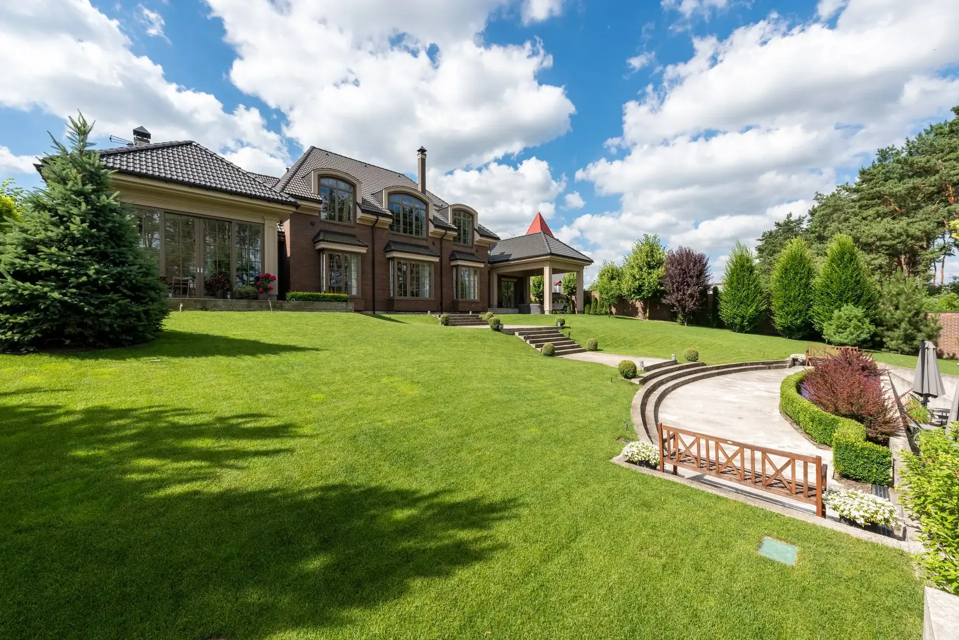A large brick estate home with a wide green lawn